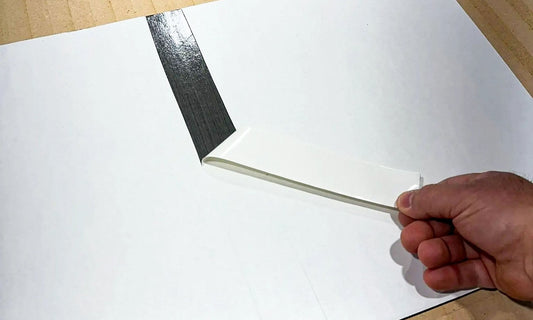 Peeling the center strip of backing off an AquaGrip EVA foam pad before install